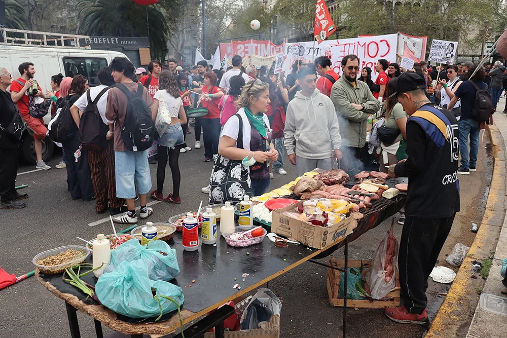 الباعة المتجولون يبيعون الأسادو أثناء المسيرة (صورة أخبار الأرجنتين)