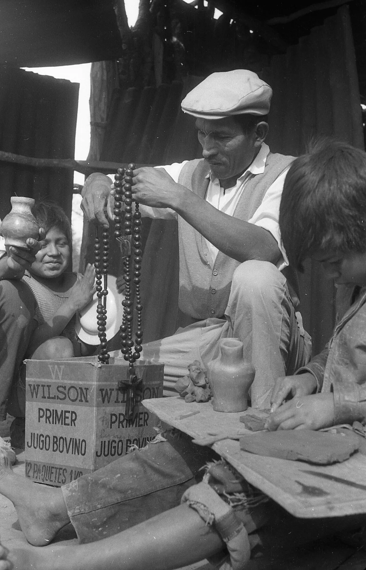 رجل مع أطفال من الكوم يصنعون المشغولات اليدوية في حيّ التوبا بمدينة ريسيستينسيا، عام 1968.